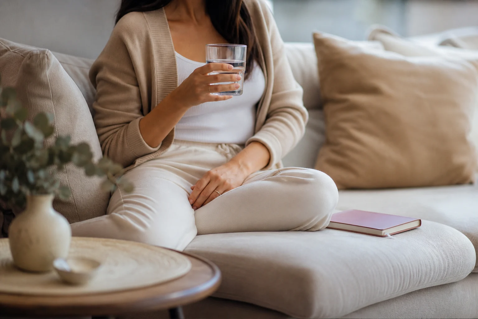 Femme buvant un verre d’eau pendant une période d’inconfort urinaire